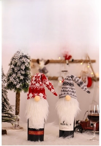 Macro detail of Christmas gnome wine bottle covers with knitted snowflake and stripe patterns