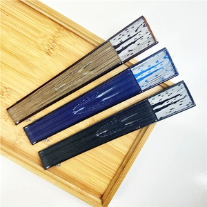 Detailed view of three Japanese folding fans in brown, blue and black on a bamboo tray