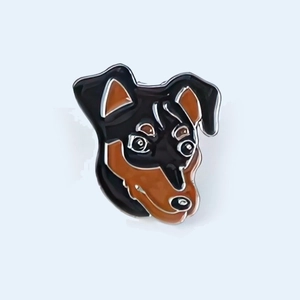 Detailed view of a cute cartoon dog enamel pin made of zinc alloy with black and brown colors