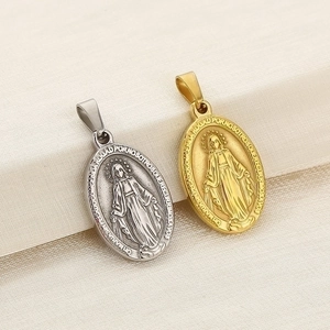 Macro detail of gold and silver stainless steel oval Virgin Mary pendant charms