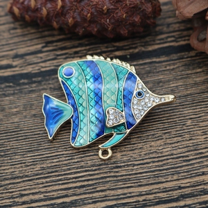 Macro shot of tropical fish pendant featuring blue enamel coating and sparkling rhinestones