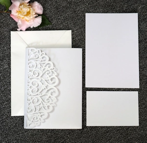 Detailed set of laser-cut white wedding invitation cards with hollow floral patterns