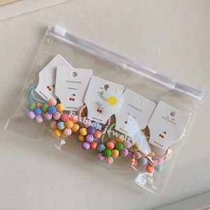 Detailansicht von 5 bunten Blumen-Haargummis in transparenter Reißverschluss-Verpackung