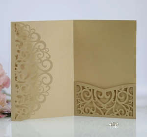 Detail of laser-cut gold wedding invitation featuring baroque patterns and pearlescent paper