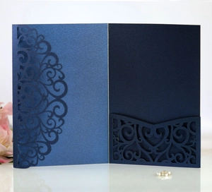 Detail of laser-cut navy pearl paper wedding invitation with floral hollow patterns