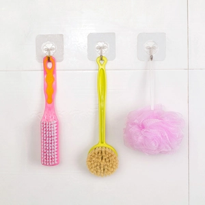 Strong transparent adhesive wall hooks showing organization of brushes on white tiles
