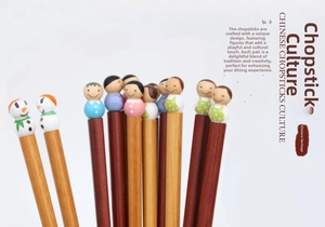 Close-up of wooden chopsticks featuring colorful hand-painted doll head finials
