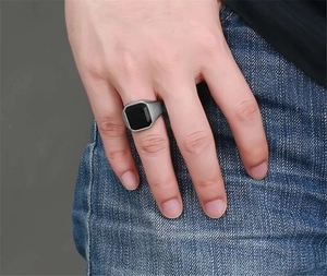Dettaglio di un anello a sigillo da uomo in acciaio inossidabile con pietra quadra nera