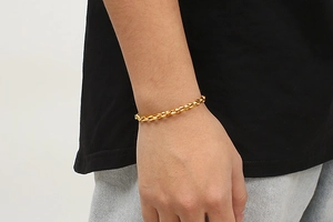 Nahaufnahme eines goldenen Schweinenase-Kettenarmbands am Handgelenk mit Gliedern
