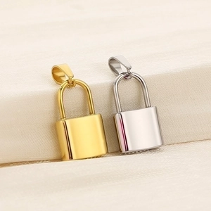 Detailed close-up of polished gold and silver stainless steel padlock pendants on fabric