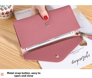 Close-up of pink long wallet with heart tassel and secure metal snap button closure