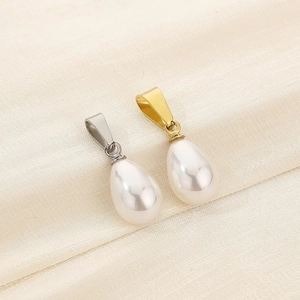 Detailed macro of white teardrop pearl pendants with gold and silver metal clasps