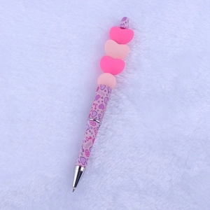 Close-up of pink Valentine silicone bead pen with heart decorations and LOVE patterns