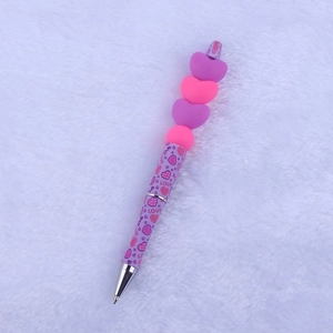 Detail of pink and purple beaded ballpoint pen with 3D stacked hearts and Love text
