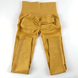 Detail of mustard yellow high-waisted yoga pants with scrunch butt lifting and ribbed texture