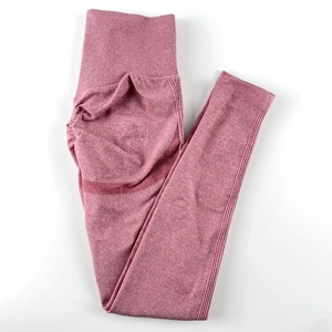 Close-up of high-waist seamless knitted yoga pants with marled rose red texture and ribbed cuffs