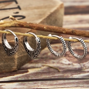Detailed view of vintage silver hoop earrings with hollow floral and spiral textures