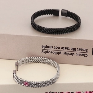 Detail van de gevlochten metalen textuur van zwarte en zilveren gevlochten mesh armbanden