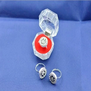 Detailansicht silberner Smiley-Ringe in einer achteckigen, klaren Schmuckschatulle