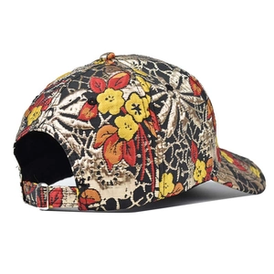 Vue détaillée de la boucle en métal argenté et du motif jacquard floral sur la casquette