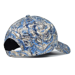 Détail de la casquette hip hop avec texture brocart bleu et or et boucle réglable en métal
