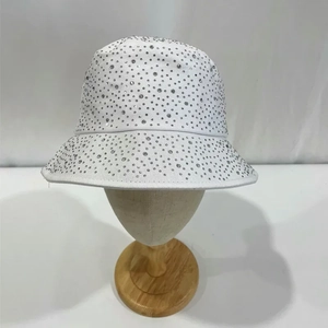 Close-up of sparkling rhinestones on a white cotton bucket hat for sun protection