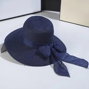 Detailed texture of navy straw sun hat with decorative mesh ribbon bow and wide brim
