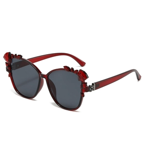 Cat eye sunglasses with dark red transparent frames and crystal floral details