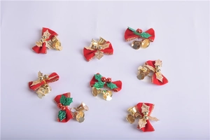 Detail of red Christmas bows with gold bells, green leaves and festive red berries
