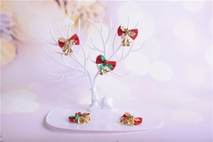 Close-up of red Christmas bows with small golden bells and holly leaves on a deer stand