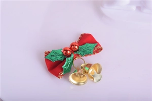 Close-up of red Christmas bow with green holly leaves, red berries, and two golden bells