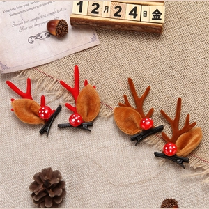 Detail view of festive reindeer antler hair clips with faux fur ears and berry accents