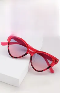 Détail de lunettes de soleil œil-de-chat rouges avec accents léopard et dégradé