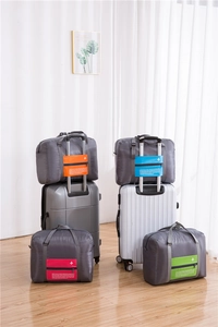 Close-up of foldable travel bags with luggage strap and Happy Flight airplane logo