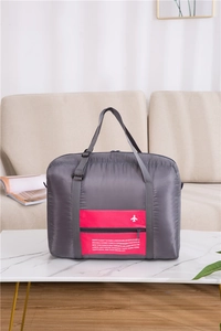 Close-up of foldable travel bag showing pink zipper pocket and waterproof nylon fabric