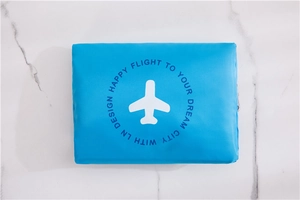 Macro view of blue waterproof travel organizer bag with white airplane icon on marble background