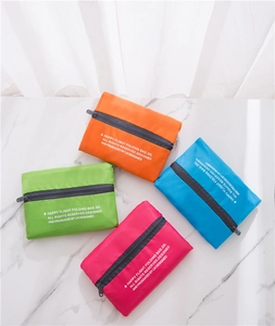 Detailed view of four colorful 32L folding nylon travel bags on marble background