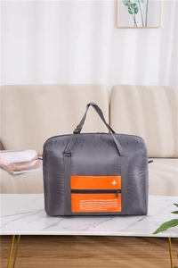 Detail view of foldable travel bag featuring grey fabric and orange zip pocket design