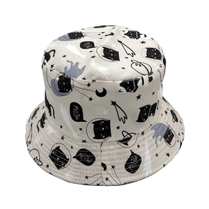 Detalle de gorro de pescador beige con gatos negros de dibujos y estampados espaciales