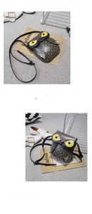 Detailed view of an owl-shaped crossbody bag in black synthetic leather with yellow accents