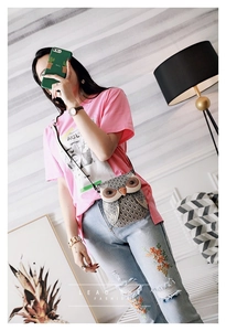 Detail of owl shaped crossbody bag with grey feather print and slim black shoulder strap
