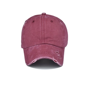 Detailed close-up of burgundy washed baseball cap featuring vintage distressed torn effects