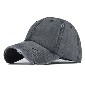 Close-up of distressed baseball cap details featuring washed grey cotton and frayed edges