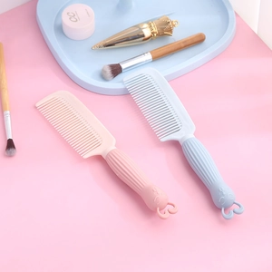 Dos lindos peines de plástico con forma de conejo en rosa y azul sobre fondo rosado