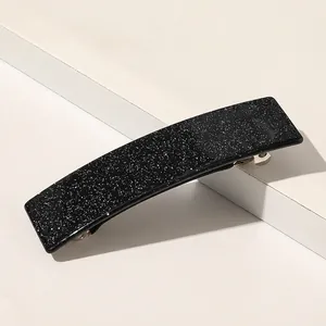 Détail de la pince à cheveux carrée noire avec paillettes blanches et ressort en métal