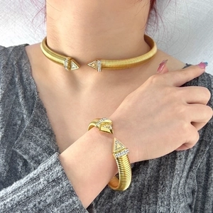 Detail view of a gold-plated snake tube necklace and bracelet set with sparkling rhinestones