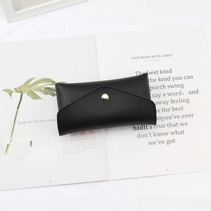 Nahaufnahme einer schwarzen PU-Leder-Umschlagtasche mit Druckknopf auf Lifestyle-Hintergrund