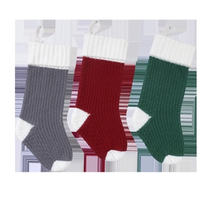 Three-color knitted Christmas stockings in grey red and green with classic white cuffs