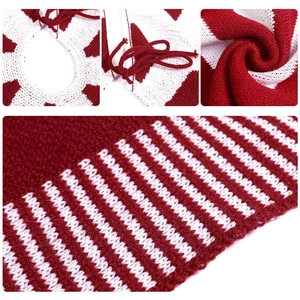 Detailed macro view of burgundy knit Christmas tree skirt with white snowflake patterns