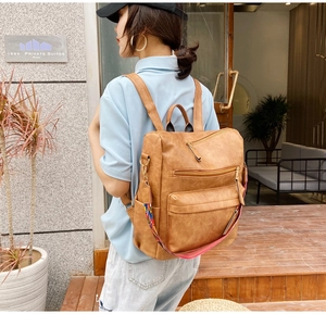 Détail d'un sac à dos vintage en similicuir marron avec sangle ethnique et poches zippées